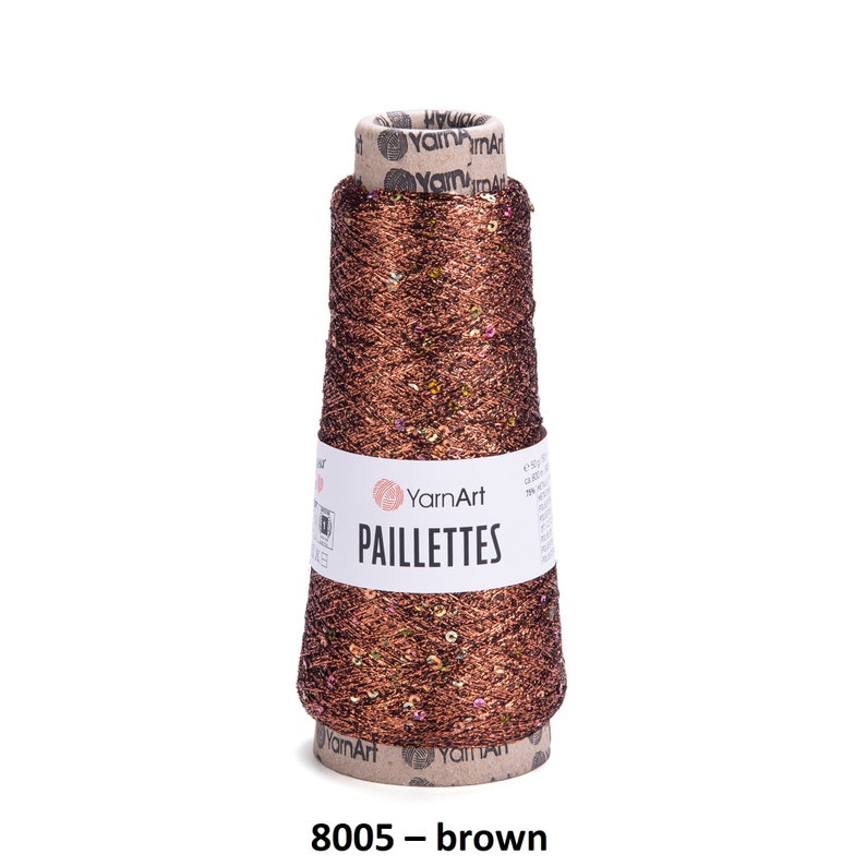May include: A spool of brown yarn with gold glitter and sequins. The yarn is labeled "YarnArt Paillettes 8005 - brown".