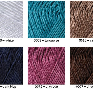 May include: Six skeins of yarn in different colors: white, turquoise, brown, dark blue, pink, and chocolate. The yarn is arranged in two rows of three skeins each. The skeins are labeled with their color and number.