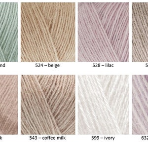 Op de afbeelding: Een verzameling garenstalen in verschillende tinten beige, roze en groen. Het garen is gerangschikt in een raster met de kleurennamen en -nummers onder elk staal.