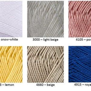 May include: Six skeins of yarn in different colors: snow-white, light beige, powder, lemon, beige, and royal blue. The yarn is arranged in two rows of three skeins each. The skeins are labeled with their corresponding color names and numbers.
