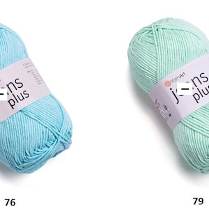 May include: Two skeins of YarnArt Jeans Plus yarn, one in light blue and one in mint green. Each skein features a white paper label with the text YarnArt Jeans plus and a small black minus symbol. The number 76 is below the blue yarn and 79 is below the green yarn.