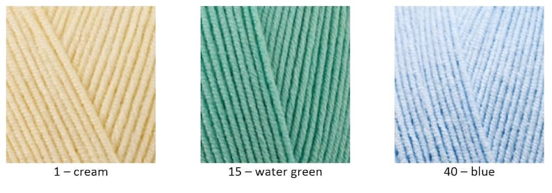 May include: Three balls of yarn in different colours: cream, water green, and blue. The yarn is labelled with numbers and colour names.