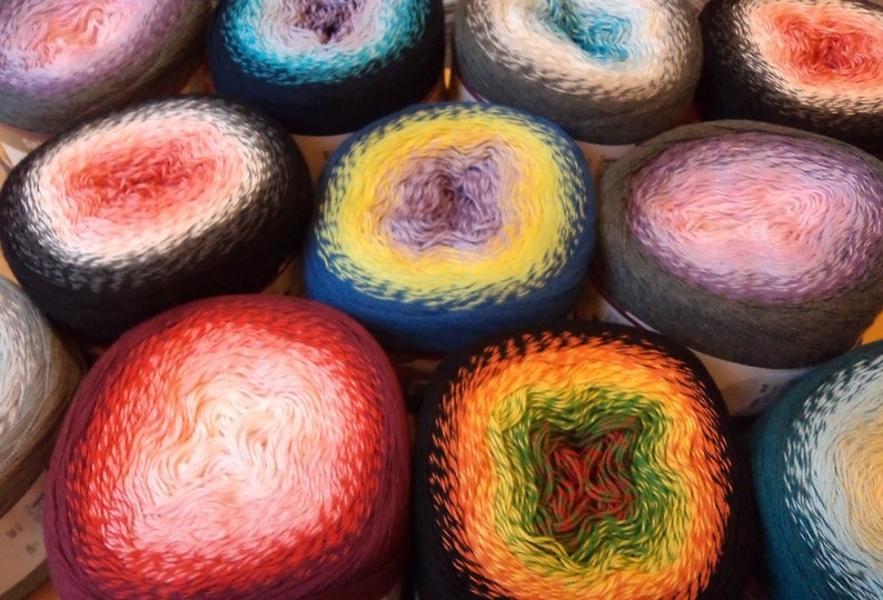 An assortment of gradient color-changing cake yarns closely arranged.