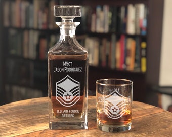 May include: A clear glass decanter and a matching glass tumbler with a gold rim. Both are engraved with the text "MSGT JASON RODRIGUEZ", a military insignia, "U.S. AIR FORCE", and "RETIRED".