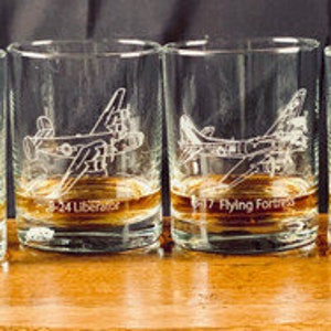 May include: Four clear glass tumblers with etched images of vintage aircraft. Each glass has a different aircraft type and name: B-29 Superfortress, B-24 Liberator, B-17 Flying Fortress, and B-25 Mitchell.