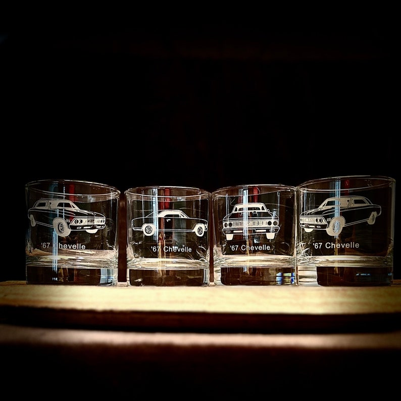 Puede incluir: Cuatro vasos transparentes de vidrio con im&aacute;genes grabadas de coches Chevelle de 1967. Cada vaso tiene el a&ntilde;o y el nombre del modelo grabado debajo de la imagen del coche.