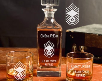 May include: A set of three personalized glasses for liquor. The glasses are engraved with the rank insignia of a Chief Master Sergeant in the U.S. Air Force, along with the name "CMSGT JR ERB" and the text "U.S. AIR FORCE RETIRED".