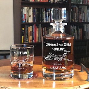 Puede incluir: Un juego de decantador y vaso personalizado con un dise&ntilde;o grabado de un avi&oacute;n C-141 Starlifter. La decantador est&aacute; grabado con "Captain Jesse Gibbs "OUTLAW" USAF AMC". El vaso est&aacute; grabado con "OUTLAW" y "C-141 Starlifter".