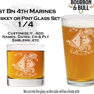 May include: Set of two etched glass whiskey or pint glasses featuring the 1st Bn 4th Marines logo. The logo includes a dragon, a diamond with stars, and the text "1st Bn 4th Mar" and "Iraq". The text "Whatever It Takes" is also included on the glasses. The glasses are filled with a light brown liquid.
