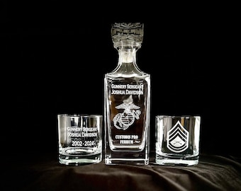 May include: A set of three clear glass decanters with engraved text and military insignia. The decanter is square shaped with a stopper. The two smaller glasses are round. The text on the decanter reads "Gunnery Sergeant Joshua Davidson 2002-2024 Custodis Pro Ferrum". The text on the smaller glasses reads "Gunnery Sergeant Joshua Davidson 2002-2024".