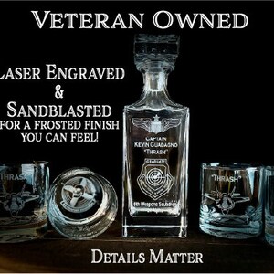 May include: A clear glass decanter with a frosted finish and laser engraved text. The text reads "Captain Kevin Guadagno "Thrash" Graduate 6th Weapons Squadron". The decanter is surrounded by three clear glass tumblers with frosted finishes and laser engraved text. The text on the tumblers reads "Thrash". The image has the text "Veteran Owned" at the top and "Laser Engraved & Sandblasted for a frosted finish you can feel!" at the bottom. The image also has the text "Details Matter" at the bottom.
