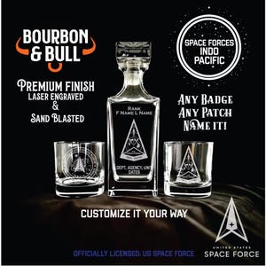 May include: A clear glass decanter and two matching glasses, all featuring the US Space Force logo. The decanter and glasses are laser engraved and sandblasted. Text on the image includes "Bourbon & Bull" and "Customize it your way."