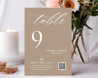 May include: A brown table number card with white text. The card says "Table 9" and "Diana & Mike Aug 22 2025". It also has a QR code and the text "Share The Love Share your photos with us! Scan the QR code with smartphone and upload your photos!"