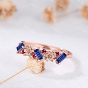 Aliança de casamento em ouro rosa com safira lapidada em baguete, rubi e design floral empilhável com pedras azuis e vermelhas. Inspirada na natureza.