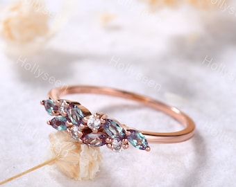 May include: A rose gold ring with a delicate design featuring a cluster of marquise-shaped alexandrite gemstones and round brilliant cut diamonds.