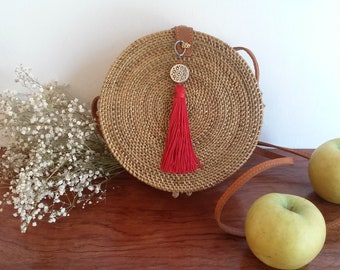 Round bag in natural rattan decorated with a pompom, with shoulder strap, vintage style summer bag, batik printed interior lining.