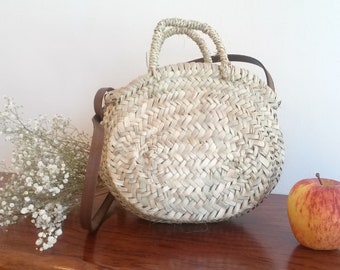 Summer tote bag in rustic straw, with shoulder strap in brown leather and short straw handles.