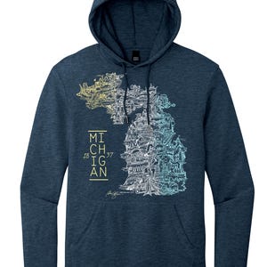 Puede incluir: Sudadera con capucha azul marino con un gráfico detallado del estado de Michigan lleno de ilustraciones arquitectónicas. La palabra "MICHIGAN" y el año "1837" están impresas en la parte delantera. La sudadera tiene un bolsillo delantero.