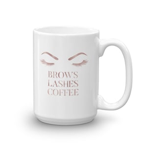 May include: White ceramic coffee mug with a rose gold design of two closed eyes with eyelashes and the text "Brows Lashes Coffee".