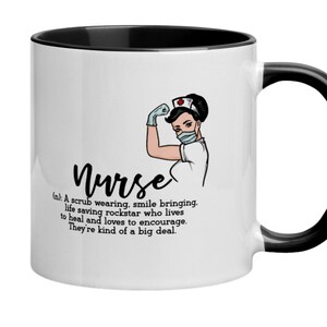 May include: White ceramic coffee mug with a black rim and handle. The mug features a cartoon illustration of a nurse wearing a face mask and a red and white nurse's cap. The text "Nurse" is written in black cursive font and a definition of the word "Nurse" is written below the illustration.