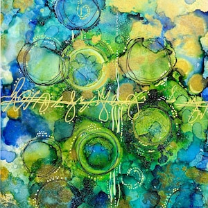 May include: Abstract watercolor painting with a vibrant mix of blues, greens, and gold. The artwork features circular shapes outlined in black, with handwritten gold script. The background has a textured, blended appearance.