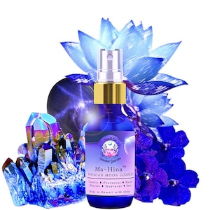 May include: A blue glass bottle with a gold cap and a spray nozzle. The bottle is labeled "Ma-Hina™ Hawaiian Moon Goddess" and lists the goddess's attributes: "Creatrix, Protector, Healer, Warrior, Nurturer, Seer". The bottle is surrounded by blue and purple flowers and crystals.