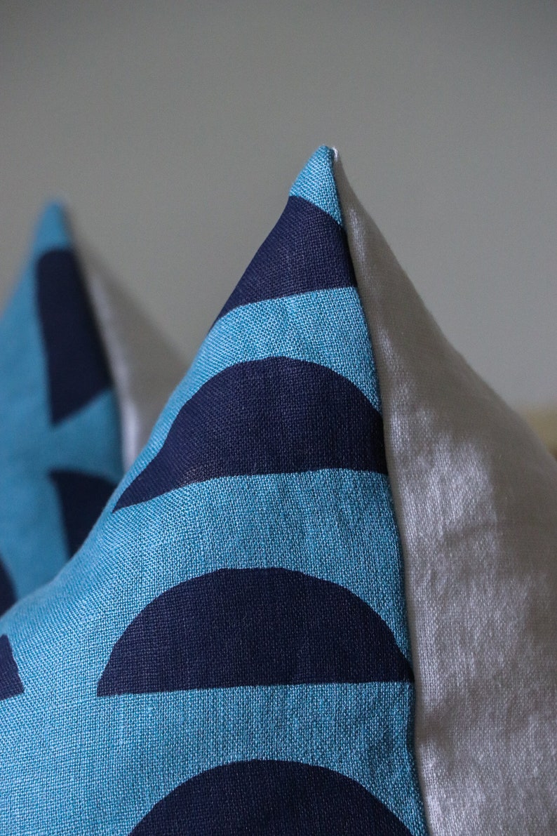 May include: Two blue and navy blue patterned throw pillows with white backing.