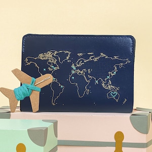 Costure onde você esteve Capa para passaporte de viagem em couro vegano - azul-marinho com mapa-múndi dourado, com agulha e linha. Personalize com suas viagens