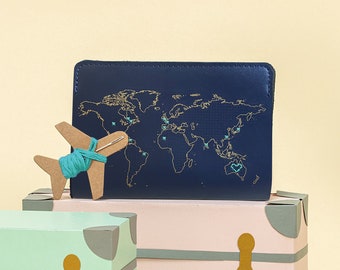 Cose tu pasaporte de viaje en cuero vegano azul marino con mapa del mundo dorado. Personalízalo con aguja e hilo.