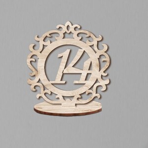 May include: Wooden table number holder with a decorative frame and the number 14 in the center.