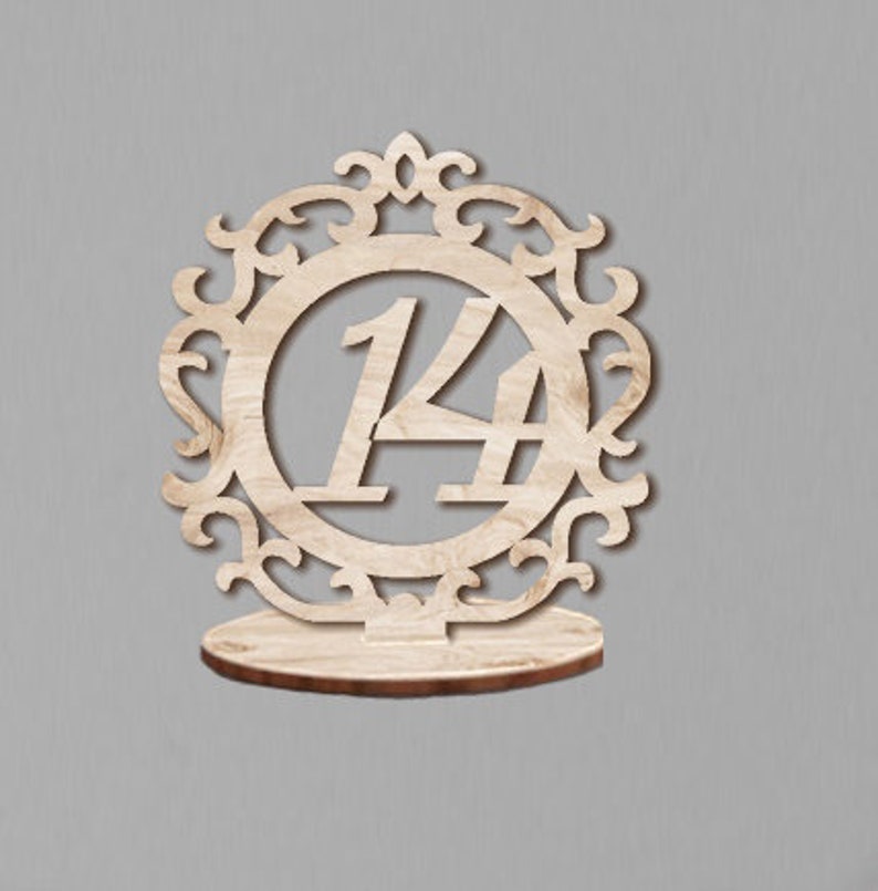 May include: Wooden table number holder with a decorative frame and the number 14 in the center.
