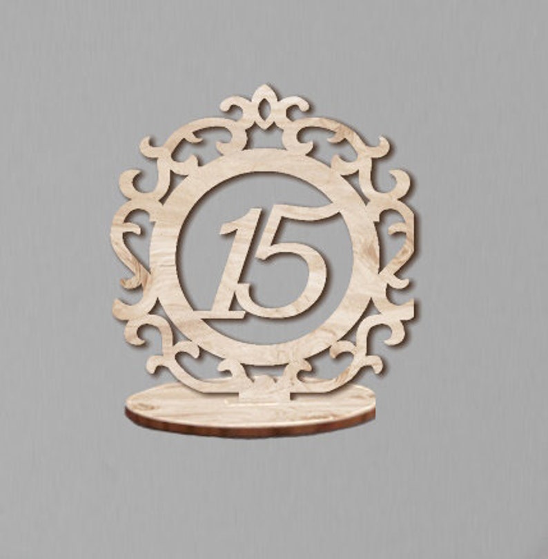 May include: Wooden table number holder with a decorative frame and the number 15 in the center.