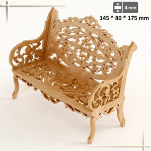 Peut inclure: Un banc en bois clair avec des sculptures florales complexes. Le banc mesure 14,5 cm x 8 cm x 17,5 cm. La conception comprend des accoudoirs et des pieds incurvés, et le dossier présente un motif ajouré détaillé. Le bois a une finition naturelle.