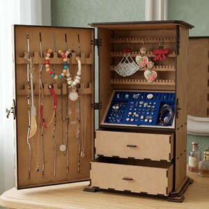 May include: A wooden jewelry armoire with an open door revealing necklaces, bracelets, and earrings. The interior features multiple storage compartments, including drawers and hanging spaces. The armoire is made of light brown wood and sits on a wooden surface.