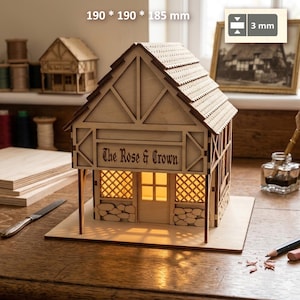 May include: A light-colored wooden model of a building named The Rose & Crown with a gabled roof, stone-textured base, and illuminated interior. The structure measures 190 by 190 by 185 mm with a material thickness of 3 mm as indicated in the image.