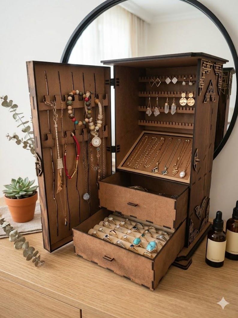 May include: A wooden jewelry armoire with multiple compartments and drawers. The open armoire displays necklaces, earrings, bracelets, and rings. The wood has a warm brown tone, and the interior is lined with beige fabric.