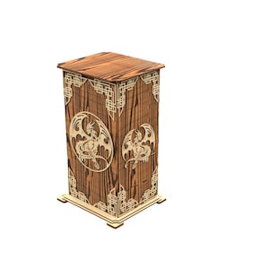 May include: A wooden box with a dragon design. The box is rectangular with a decorative top and base. The sides feature laser-cut dragon silhouettes within oval frames and geometric patterns. The wood has a warm, natural tone.