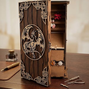 May include: A wooden jewelry box with a dragon design. The box is made of dark brown wood with a laser-cut dragon in a circle on the front. The box is open, revealing compartments for jewelry. The box has a decorative geometric design on the edges.