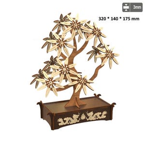 Puede incluir: Modelo de bonsái de madera con hojas de color marrón claro y tronco marrón oscuro. El árbol se encuentra en una base rectangular marrón oscuro con un diseño decorativo de dragón. Dimensiones: 320 x 140 x 175 mm.