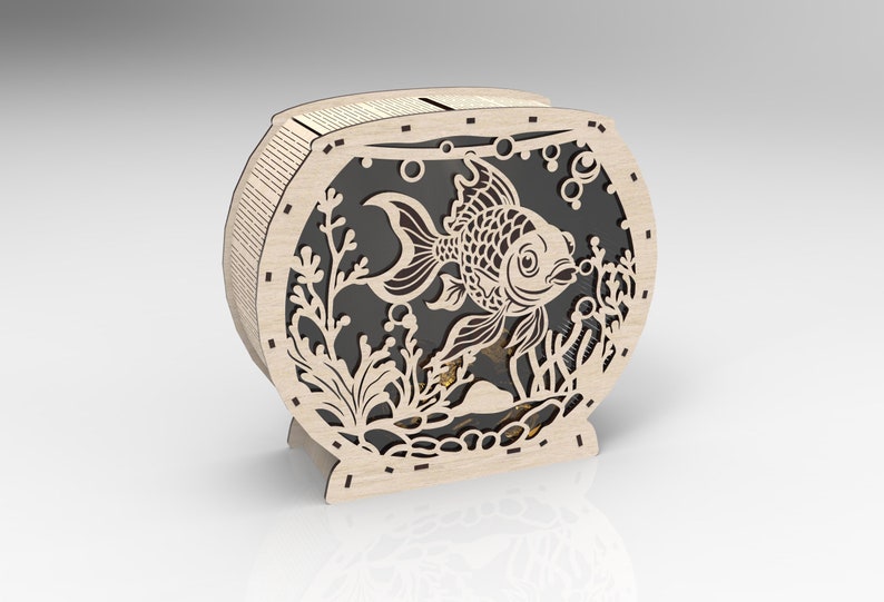 May include: A wooden cutout of a fishbowl with a goldfish inside. The fishbowl is decorated with seaweed and bubbles. The cutout is made of light brown wood and has a black background.