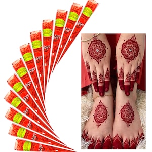 Può includere: Dieci coni di henné rossi con il testo "Mehndi" e "byo" stampato su di essi. I coni sono disposti a forma di ventaglio. Un paio di mani con disegni di henné sono mostrate sullo sfondo.