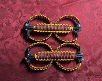 May include: Four paracord door handles with a maroon and yellow braided design. The handles are attached to black straps with metal rings.