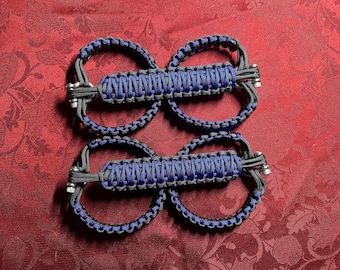 May include: A pair of black and blue paracord door handles with metal hardware. The handles are made with a braided rope design.