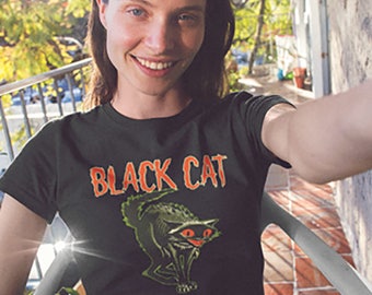 May include: A black t-shirt featuring a graphic of a black cat with orange eyes and the text "BLACK CAT" in orange.