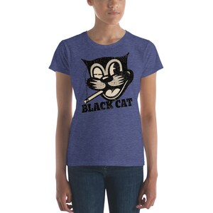 Puede incluir: Una camiseta de mujer azul jaspeada con una imagen de dibujos animados en blanco y negro de un gato fumando un cigarrillo. El texto "BLACK CAT" est&aacute; impreso debajo de la imagen.