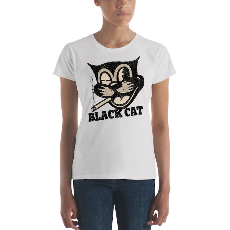 Puede incluir: Camiseta blanca para mujer con un gato de dibujos animados en blanco y negro fumando un cigarrillo. El texto "BLACK CAT" est&aacute; impreso debajo del gato.