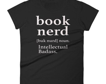 May include: Black women's t-shirt with white text that reads "book nerd [buk nerd] noun. Intellectual Badass."