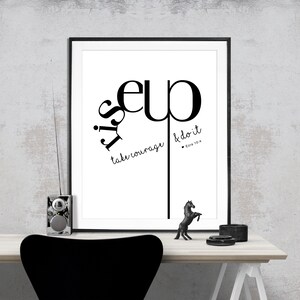 May include: Black and white typography print with the words "It is up to you" and "take courage & do it" with a quote from Ezra 10:4. The print is framed in a black frame and is hanging on a white wall.