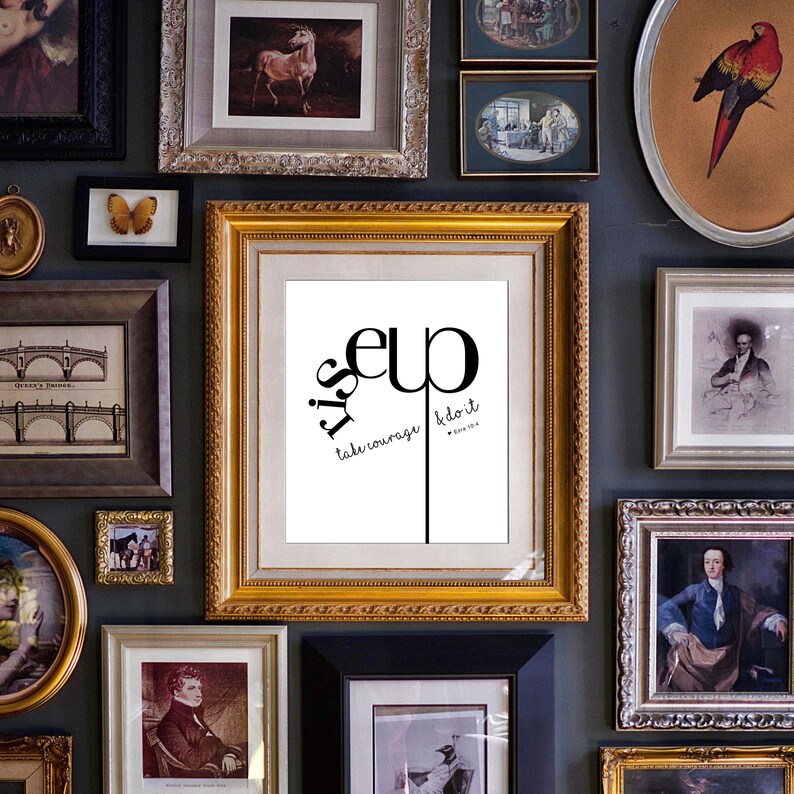 May include: A framed print with a black and white design that says "It's up to you, take courage & do it". The print is surrounded by a gold frame and is hanging on a wall with other framed prints.