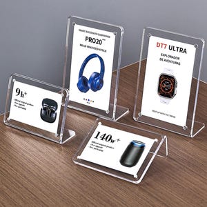 Puede incluir: Cuatro expositores de acrílico transparente con diferentes productos en su interior. Los expositores están inclinados y tienen un pequeño borde en la parte delantera. Los productos incluyen unos auriculares, un reloj inteligente, un par de auriculares y un altavoz. El texto en los expositores dice "PRO20", "DT7 ULTRA", "9h+" y "140w+".